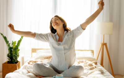 Happy woman enjoys morning coffee in the bedroom with houseplant